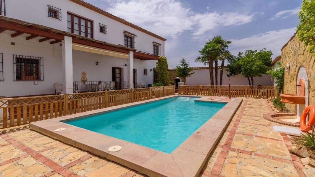 a swimming pool in front of a house at Casa Rural Aire Fuente de Piedra by Ruralidays in Fuente de Piedra