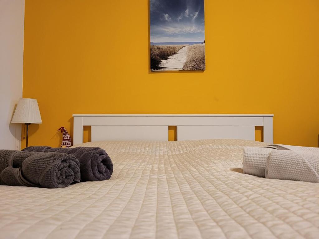 ein Schlafzimmer mit einem großen Bett mit gelber Wand in der Unterkunft Leopoldauer Apartment in Wien