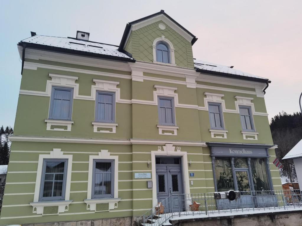 ein gelbes und grünes Haus mit einem Fenster in der Unterkunft Konrad-Haus - DorfResort Mitterbach in Mitterbach