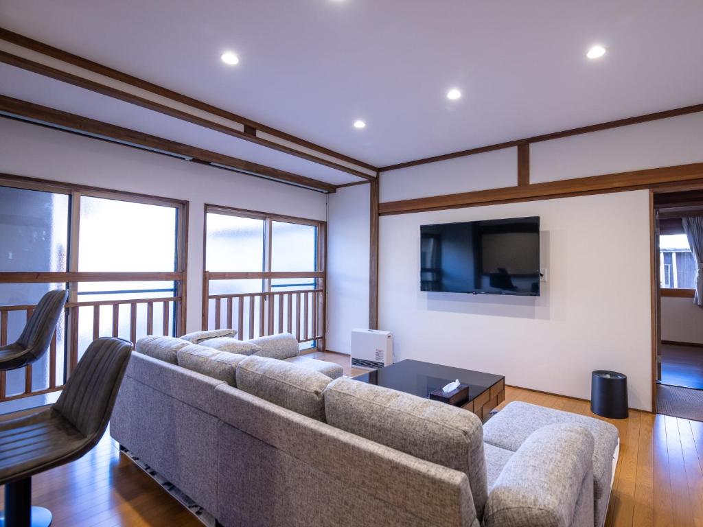 a living room with a couch and a flat screen tv at Norichanchi in Nozawa Onsen