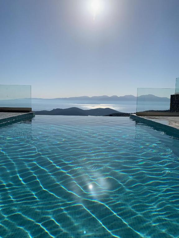 a swimming pool with a view of the water at La Villa Havgas in Elounda