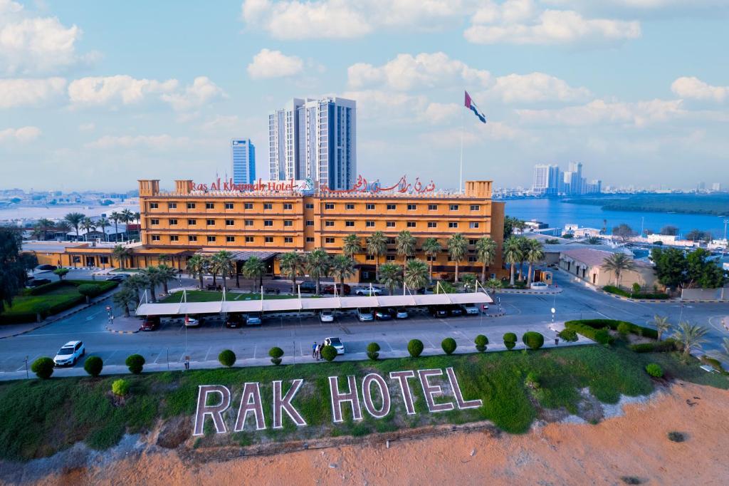 a large hotel with a kite flying over a city at Ras Al Khaimah Hotel in Ras al Khaimah