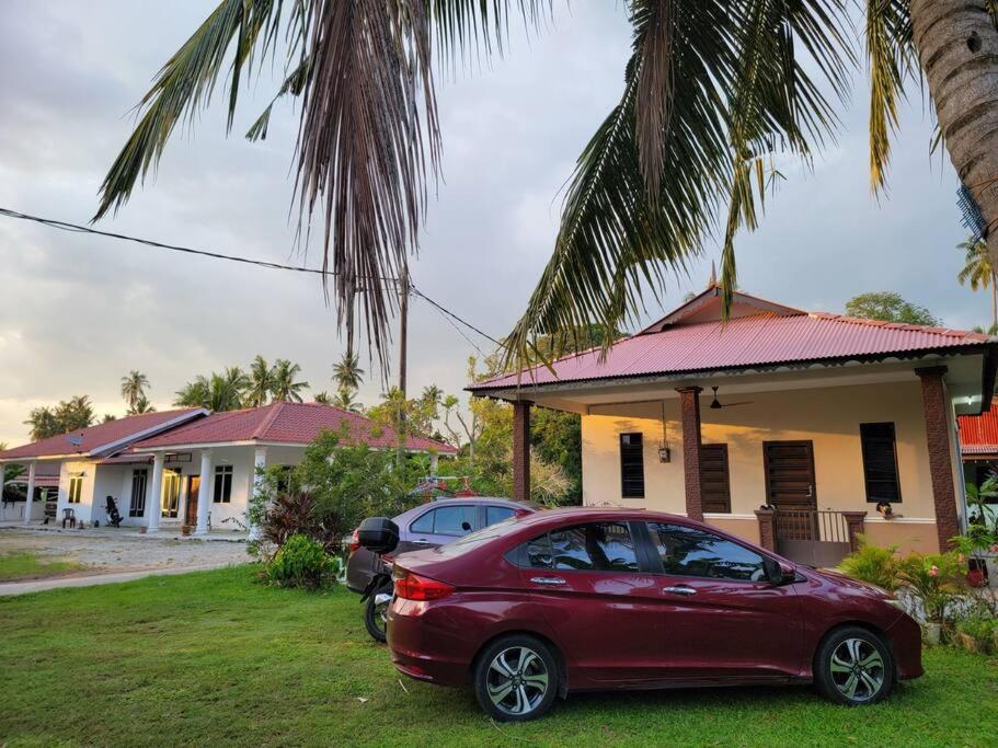 a red car parked in front of a house at NusaTuah Roomstay in Melaka