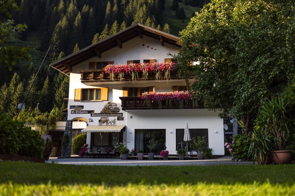 un edificio blanco con flores en los balcones en Pension Christophorus Hotel Garni en Partenen