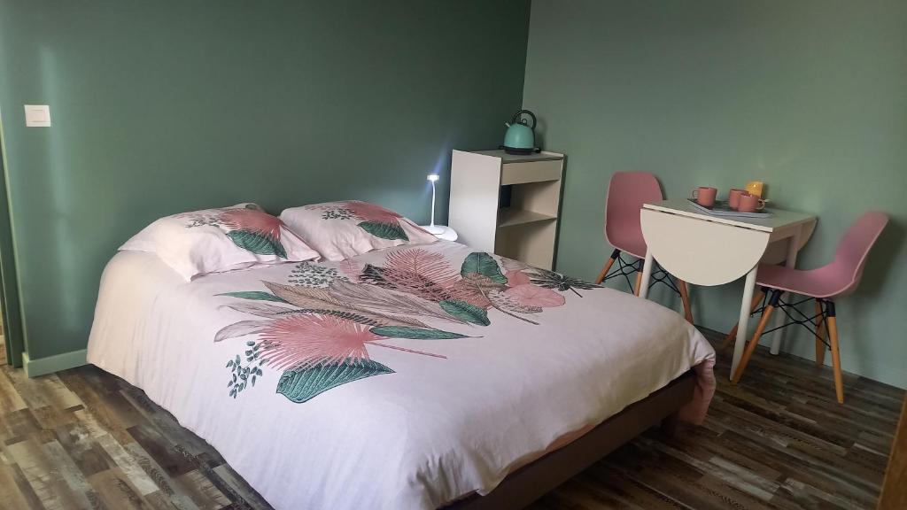 een slaapkamer met een bed en een tafel en stoelen bij Chambre privée in Le Bugue