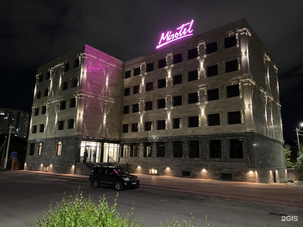 un edificio con un letrero de neón encima en MirOtel Hotel, en Astana