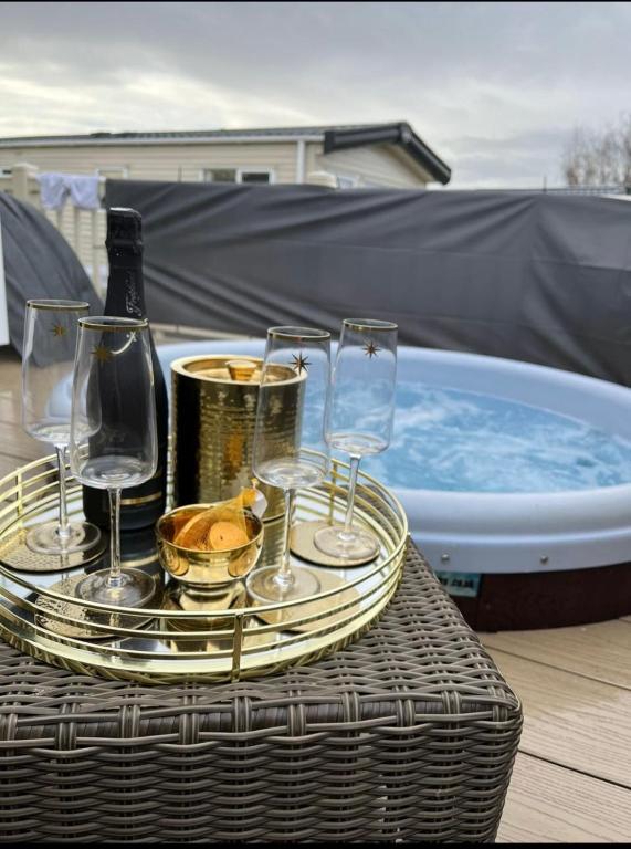 a tray of wine glasses and a tub of water at Hot tub breaks Fairways Tattershall lakes in Tattershall