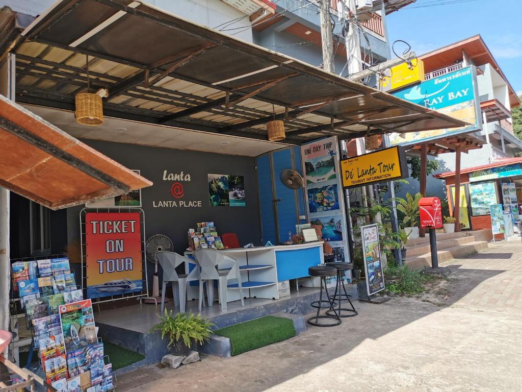 a book store with a table and chairs on a street at De​ Lanta place in Ko Lanta
