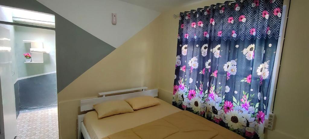 Dormitorio pequeño con cama con cortina en Cenggo Homestay en Ruteng