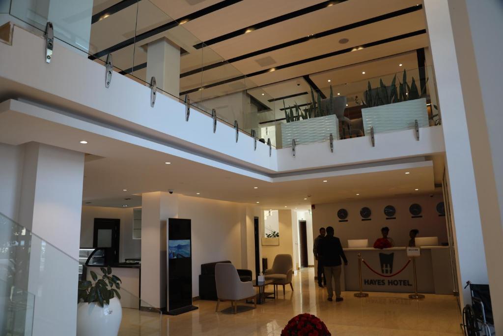 a person walking through a lobby with a staircase at Hayes Hotel, Addis Ababa in Addis Ababa