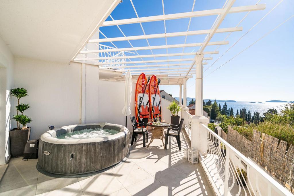 - un bain à remous sur un balcon avec une table et des chaises dans l'établissement Apartments Blažević, à Mlini