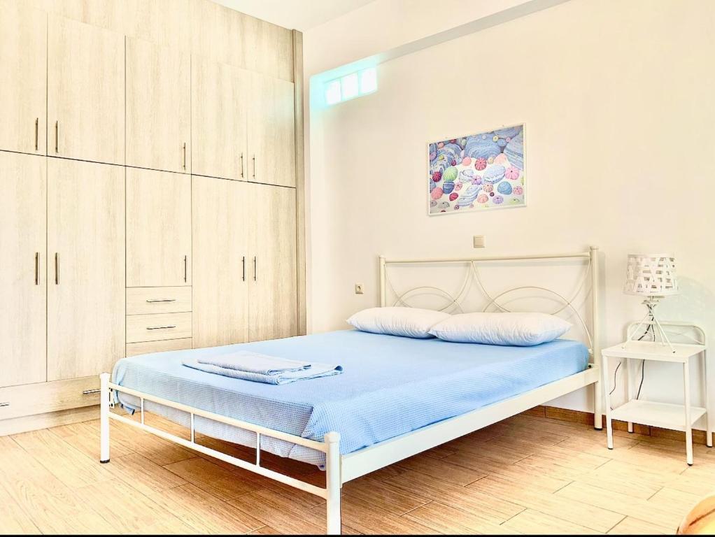 Schlafzimmer mit einem Bett mit blauer Bettwäsche und Schränken in der Unterkunft House Marina in Paránimfoi