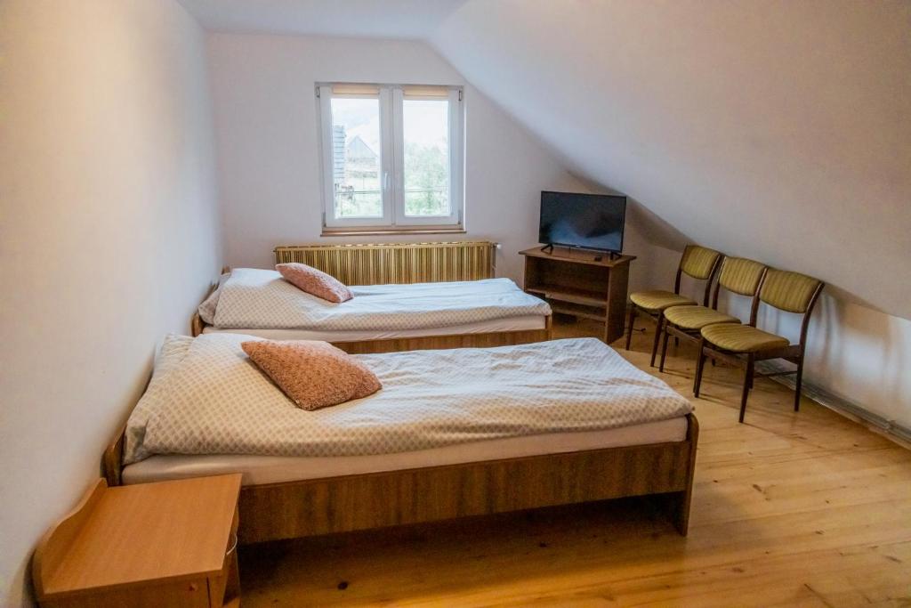 a attic room with two beds and a window at Beskidzki Klimat Jaśliska in Jaśliska