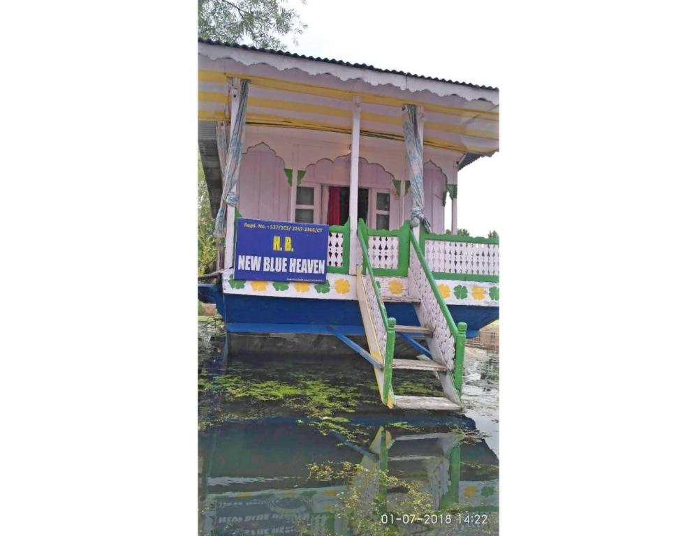 Blue heaven House boat, Srinagar في سريناغار: قارب في الماء امام المنزل