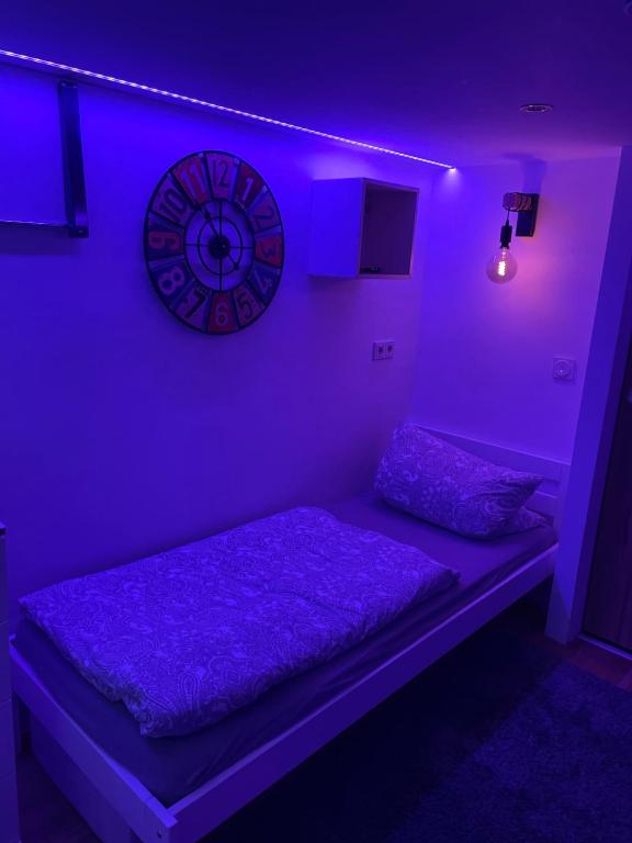 Habitación con cama con reloj en la pared en sweet Lounge international TV Netflix WIFI, en Ehringshausen