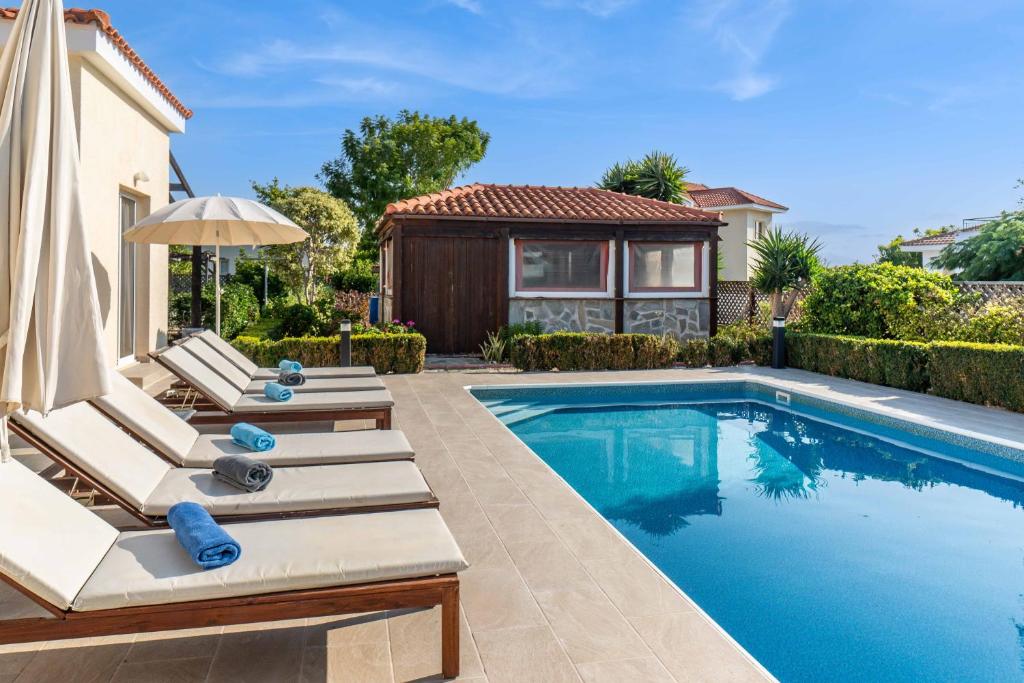 una piscina con tumbonas y una casa en Bungalow Summerside by Ezoria Villas, en Bahía de Coral