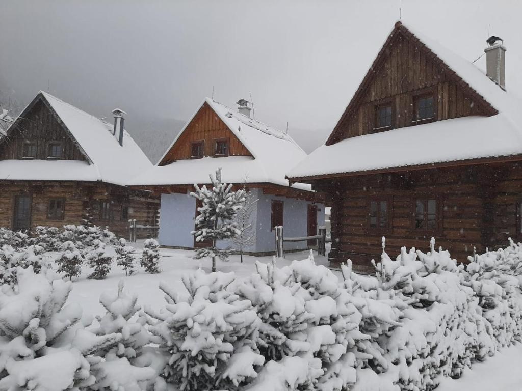 een sneeuwbedekte tuin voor sommige gebouwen bij Rezort Gothal Chalupy in Donovaly
