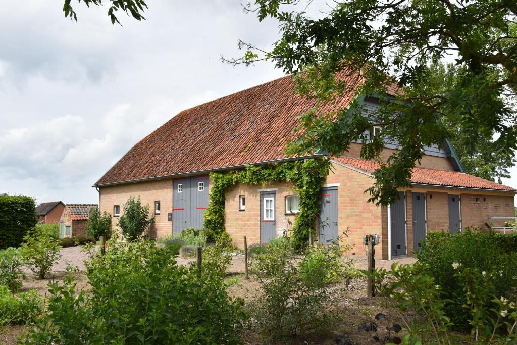 an old brick house with a brown roof at Het Zilte in Zuidzande