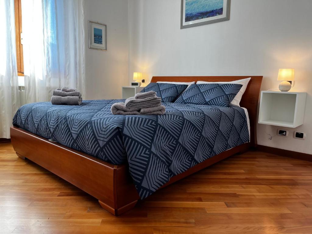 1 dormitorio con cama con edredón y almohadas azules en Dimora Ossolana, en Domodossola