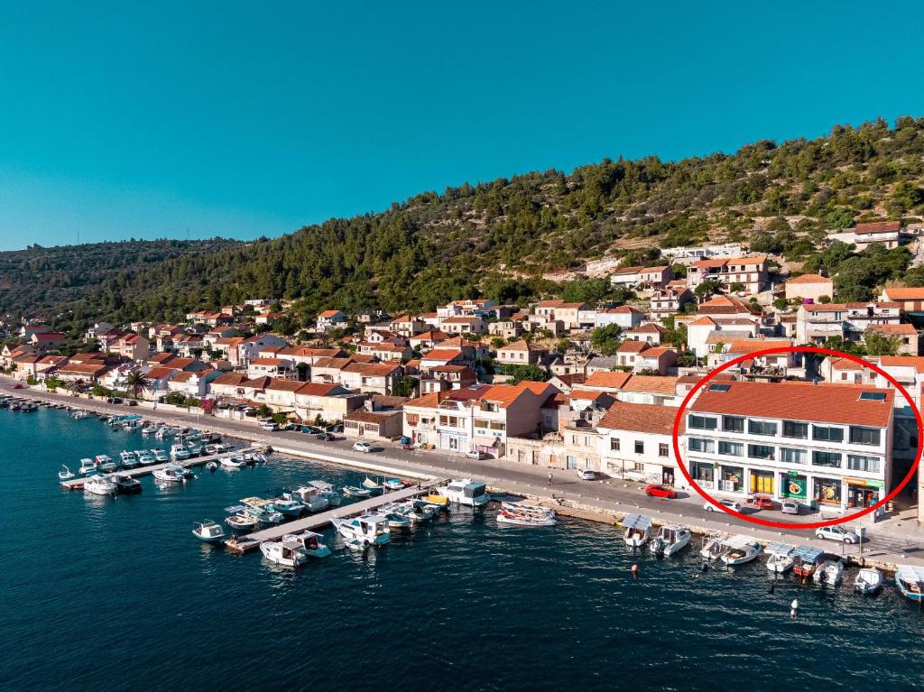 a group of boats in a marina with a red circle at Apartments & Rooms Fisherman's Luck in Vela Luka