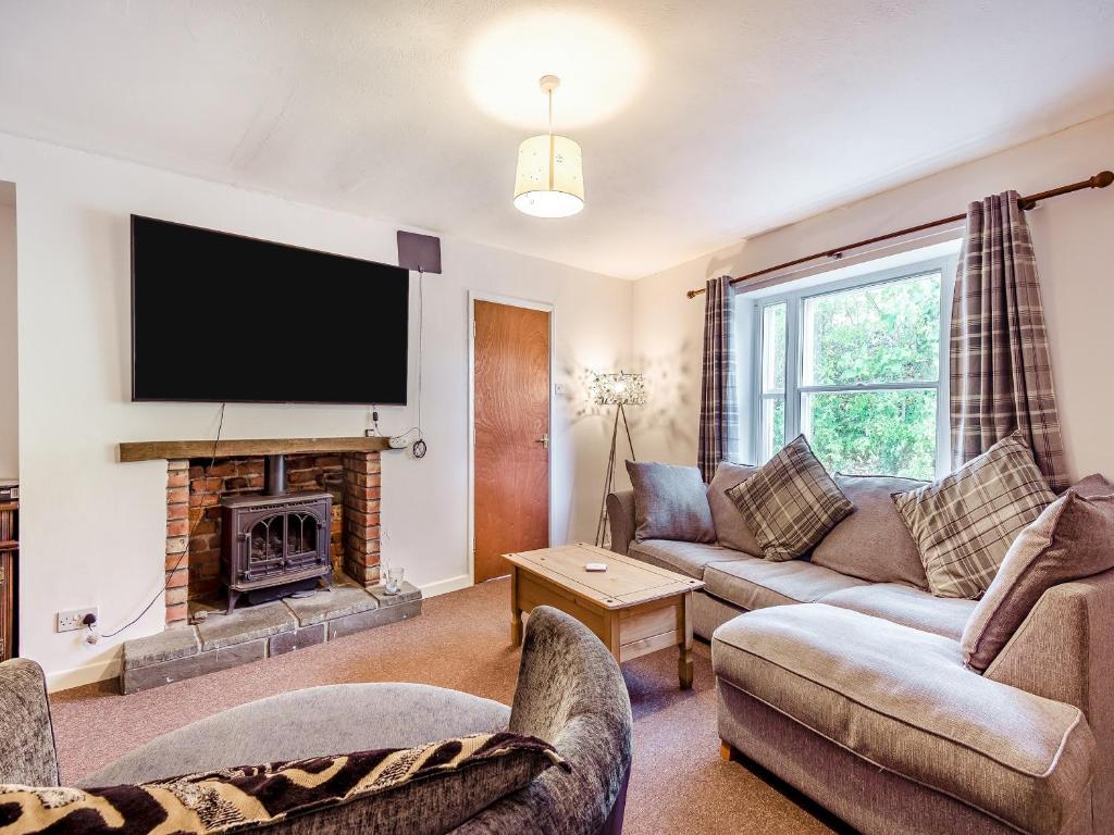 a living room with a couch and a fireplace at Harp Cottage in Brecon