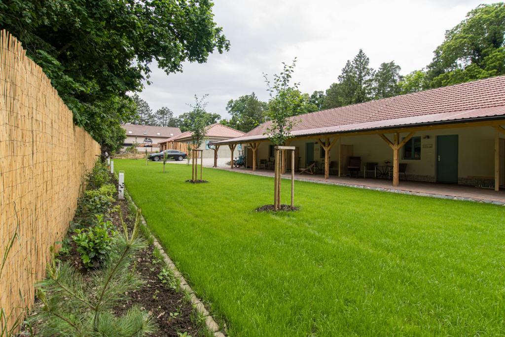 a yard with trees in the grass next to a building at Apartmány Uprostřed zeleně in Lednice