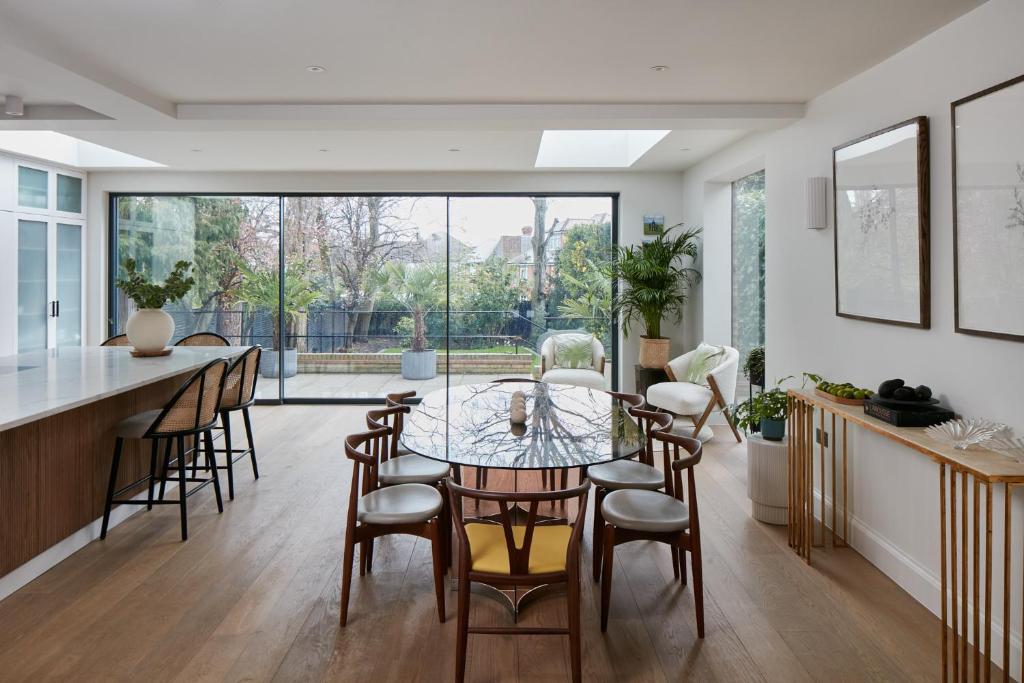 a kitchen and dining room with a glass table and chairs at Veeve - Pine Reflections in London