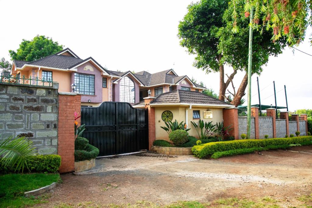 una casa con una puerta negra y una valla en Davis Court, en Nyeri
