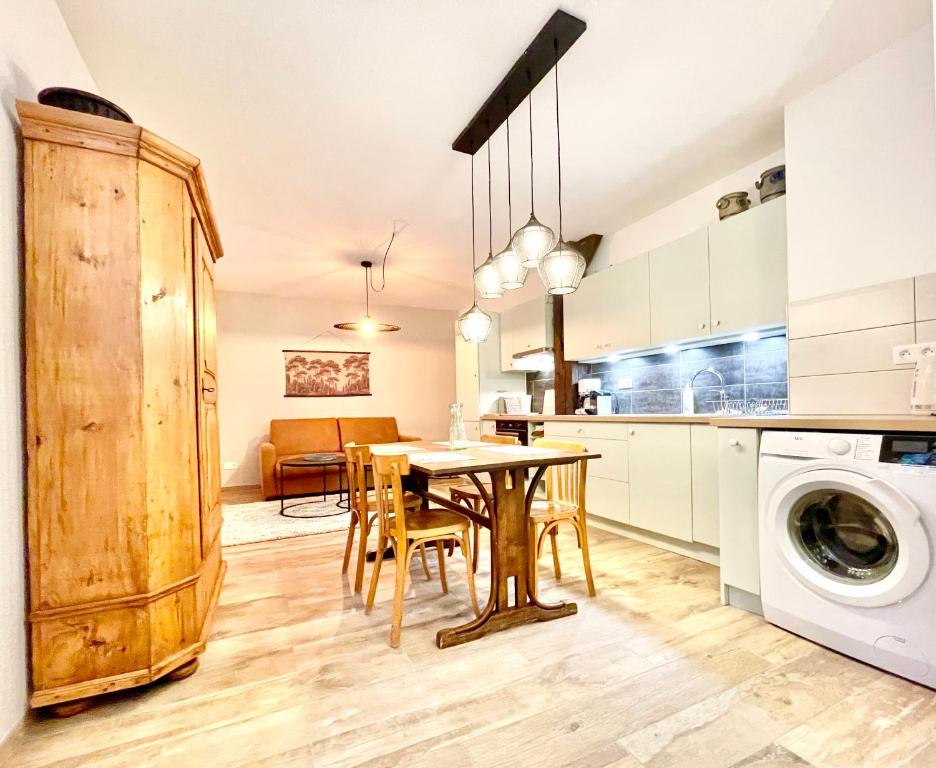 een keuken en eetkamer met een tafel en een wasmachine bij Colmar - Parking Gratuit - Le Nichoir - Centre historique - Wifi in Colmar