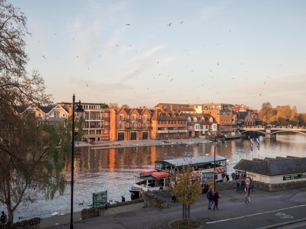 a view of a river with buildings and a bridge at Radiant Penthouse on the Banks of the Thames in Windsor