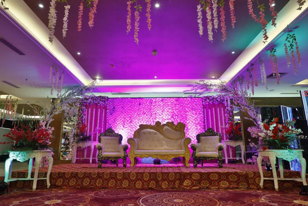 - une salle de banquet de mariage avec éclairage violet et chaises dans l'établissement Mannat Haveli, à Kurukshetra