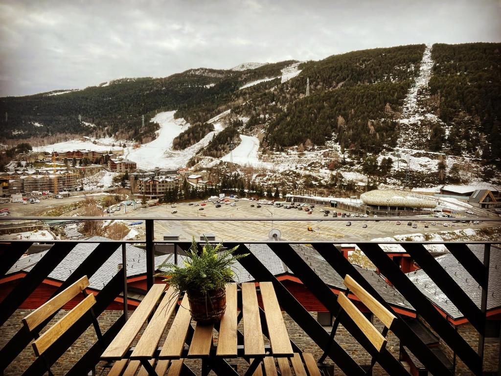 um banco de madeira sentado no topo de uma pista de esqui em Apartament Mufló Apartamento encantador con vistas espectaculares a la X de Grandvalira em El Tarter