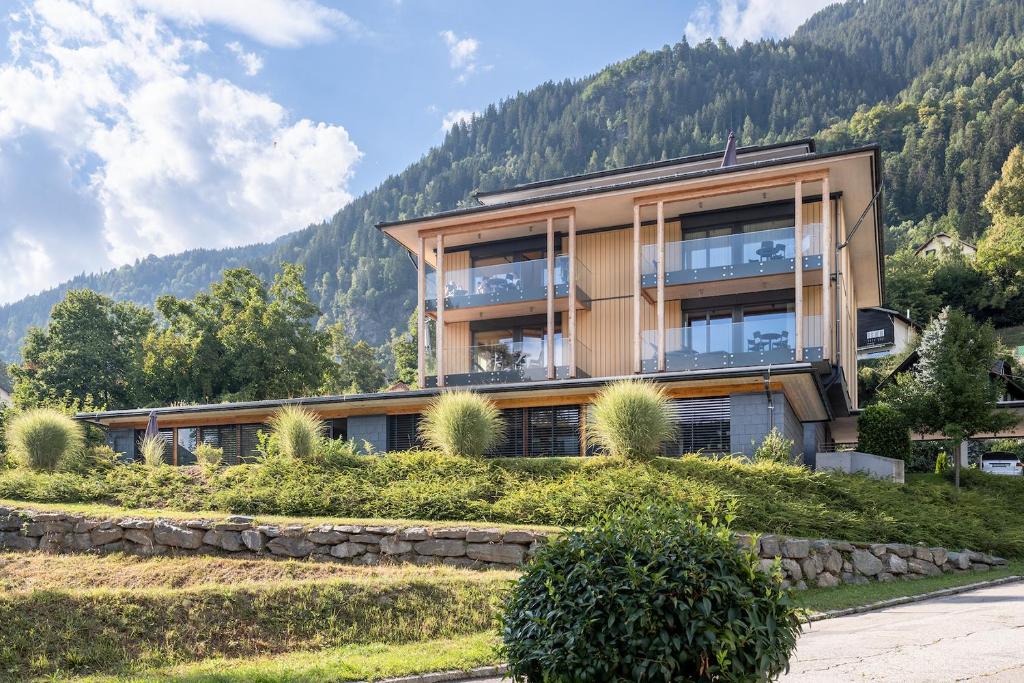 una casa en una colina con montañas en el fondo en Atelier Ronacher en Annenheim