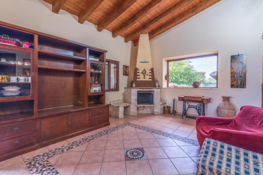 sala de estar con sofá rojo y chimenea en Villa Gabri en Carlentini