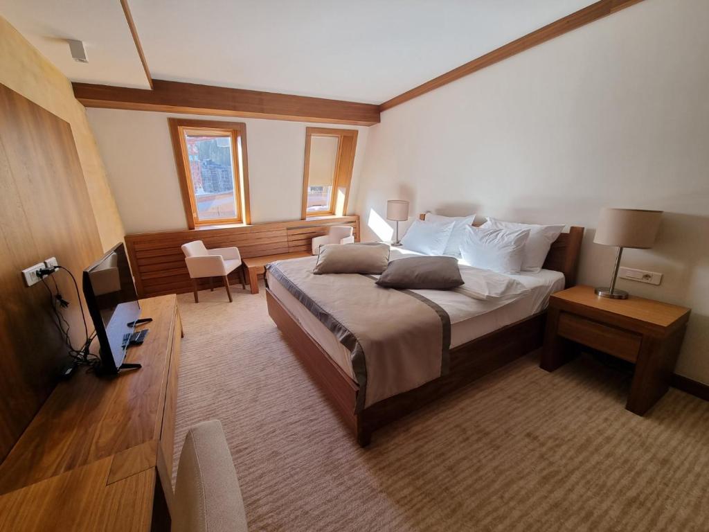 ein Schlafzimmer mit einem großen Bett und einem Fernseher in der Unterkunft RT APARTMANI VUČKO JAHORINA in Jahorina