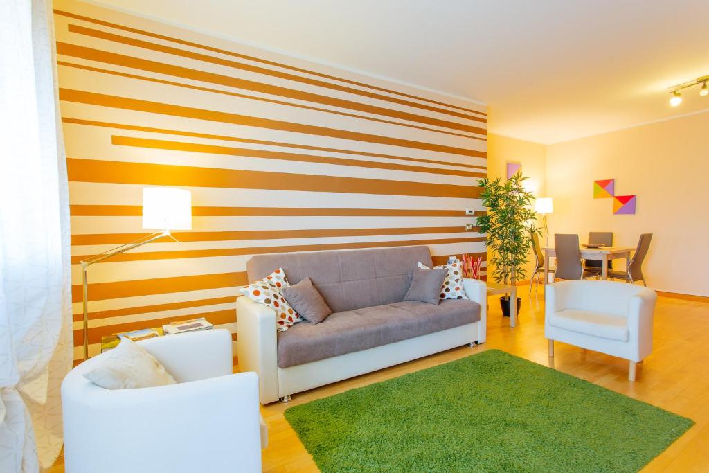 a living room with a couch and a striped wall at Yourbanflat Sweet Home in Padova