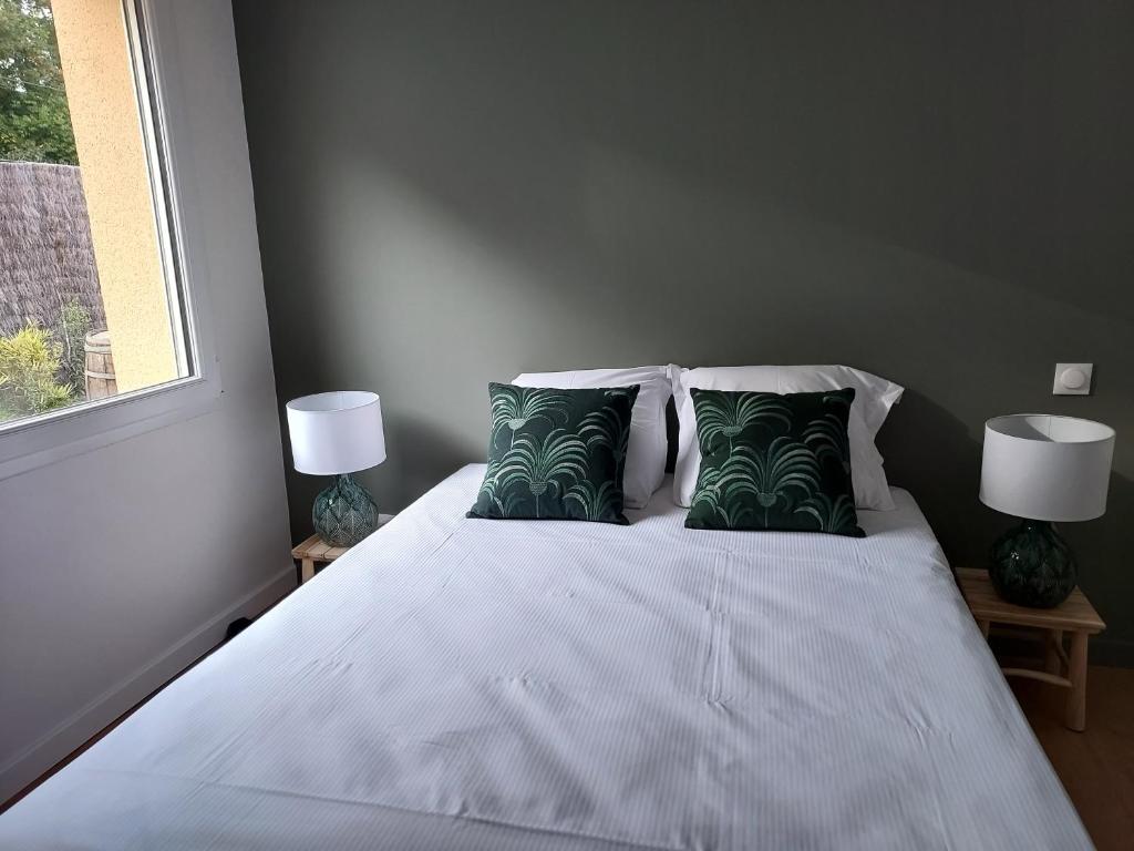 a bedroom with a large white bed with two lamps at La Clé du Chesnot in Saint-Quentin-sur-le-Homme