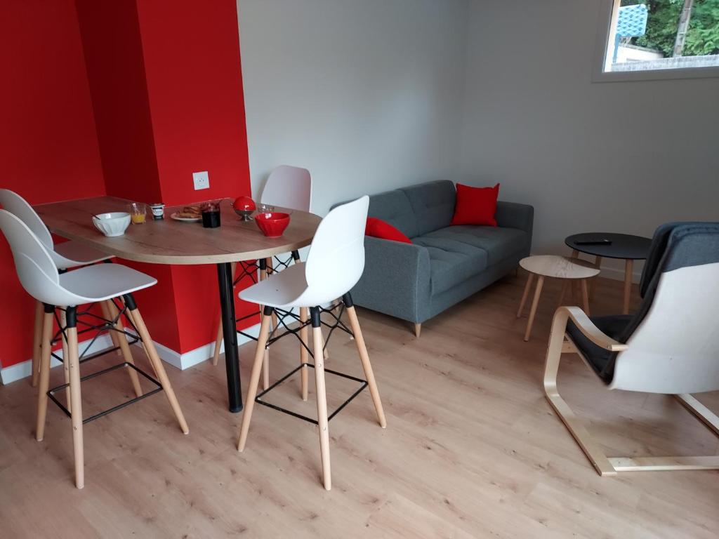 a living room with a table and chairs and a couch at La Clé du Chesnot in Saint-Quentin-sur-le-Homme