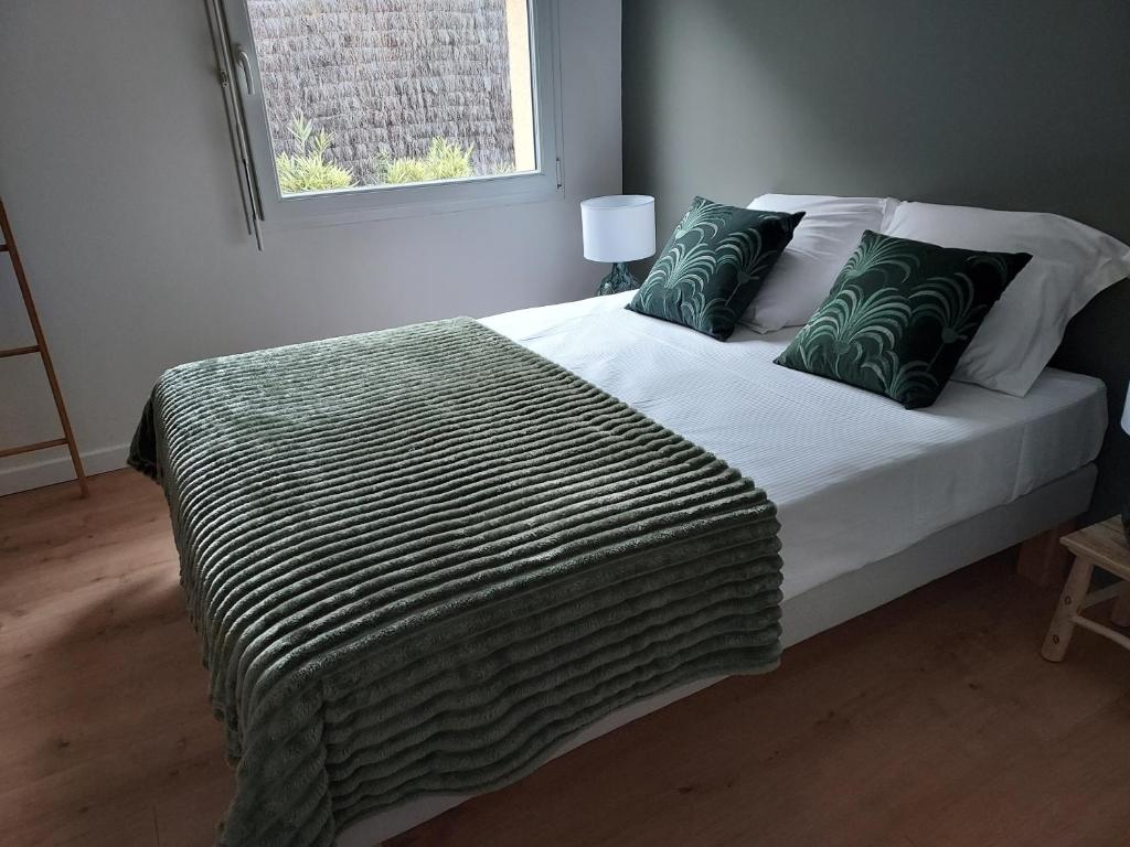 una camera da letto con un grande letto con cuscini verdi di La Clé du Chesnot a Saint-Quentin-sur-le-Homme