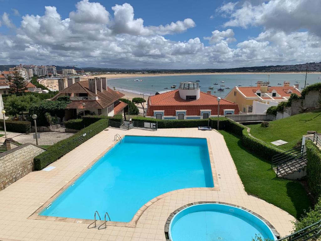 a large swimming pool with a view of the water at Casa na onda Sonho da Baia in São Martinho do Porto