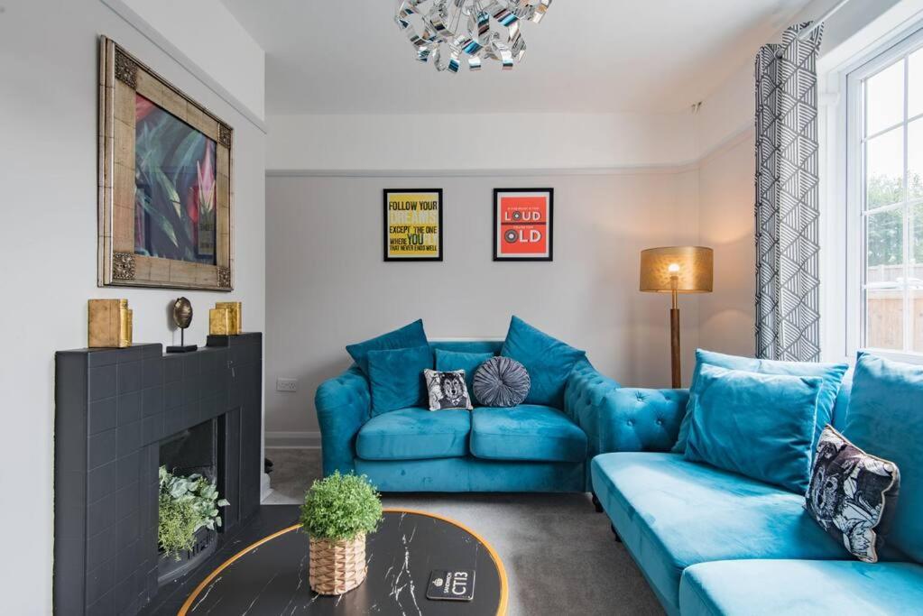 a living room with a blue couch and a fireplace at 19th Hole in Sandwich