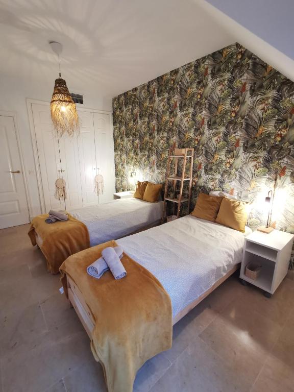 a bedroom with two beds and a wall with a mural at Penthouse 6-8 personnes in Manilva