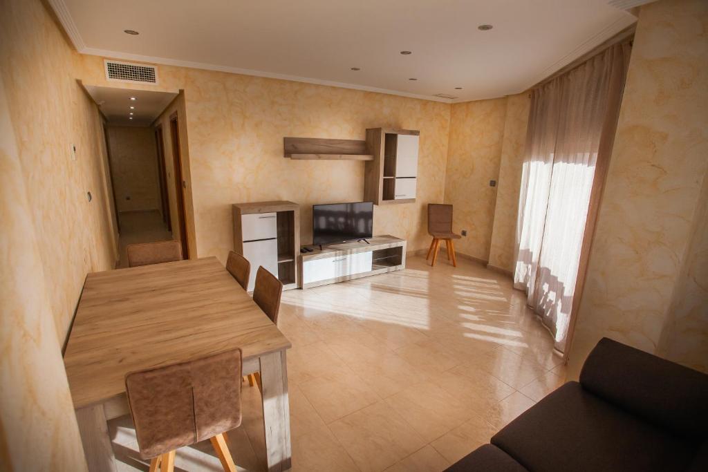 Il comprend un salon avec une table en bois et une cuisine. dans l'établissement PISO SAN ISIDRO (ALICANTE), à Alicante