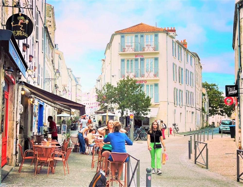 two women walking down a street in a city at Hôtel Le Bord'O Vieux Port in La Rochelle