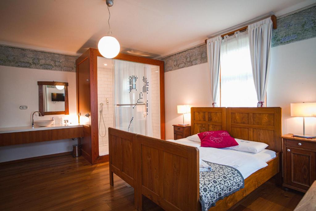 a bedroom with a bed and a sink in it at Pr'Gavedarjo Eco Heritage B&B in Kranjska Gora