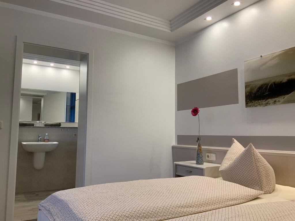 a white bedroom with a bed and a sink at Pension Villa Transvaal in Ahlbeck