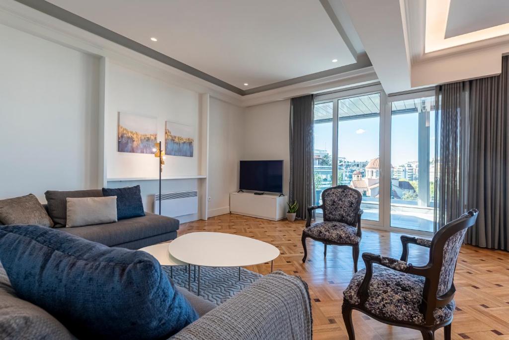 een woonkamer met een bank en een tafel en stoelen bij Phaedrus Living City Center Luxury Flat Neos Kosmos in Athene