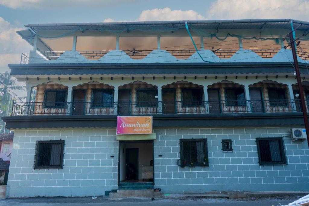- un bâtiment bleu avec un balcon en haut dans l'établissement Anandvan Beach Resort, à Alibaug