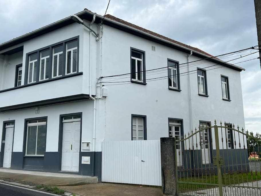 uma casa branca com uma cerca à frente. em Apartamento A em Irijoa