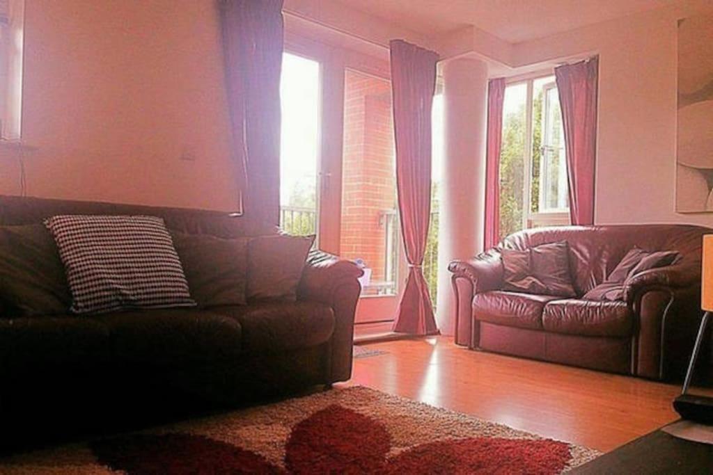 a living room with two leather couches and a window at Superhost 1 bedroom flat 15 mins to center,zone 2. in London